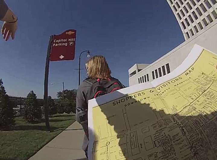 Photograph of participants carrying a historic map as they walk along a city street