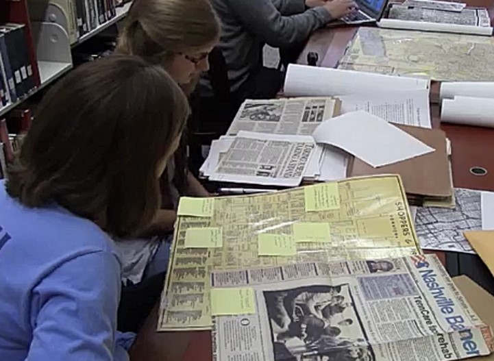 Photograph of students working with archival materials in a public library