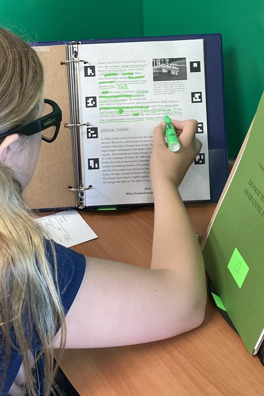 A student highlights while reading on paper with the Tobii Glasses